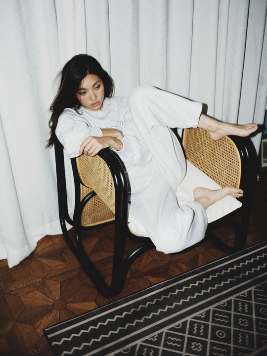 一个穿着白色长袍的年轻女子坐在椅子上