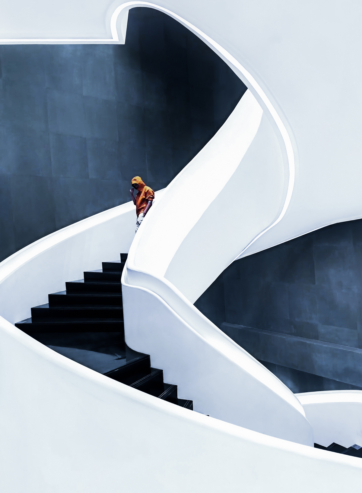 一个人走上一个白色的螺旋楼梯