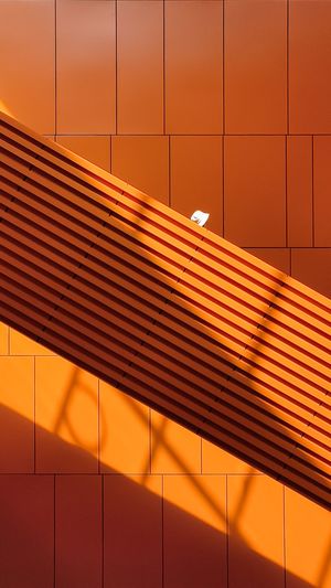 一栋橙色墙壁的建筑 楼梯在投射出阴影。