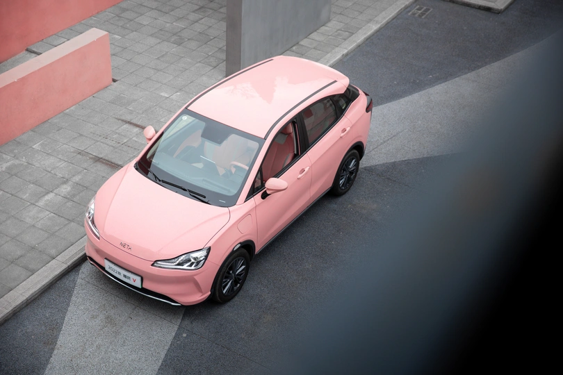 路边停着一辆小粉红色汽车