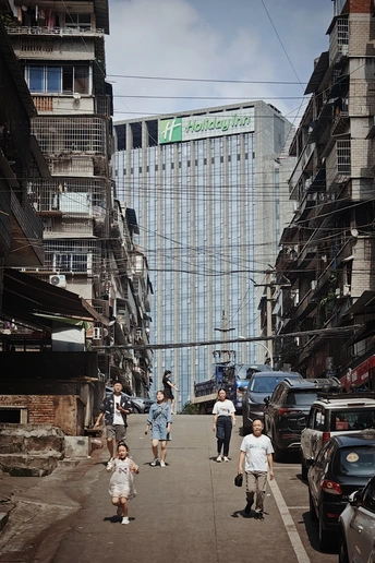 一条街道 有高楼、汽车和人行道上有行人。