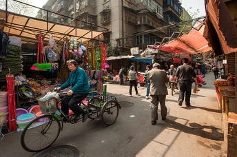 一个人骑自行车在市场旁边的街道上