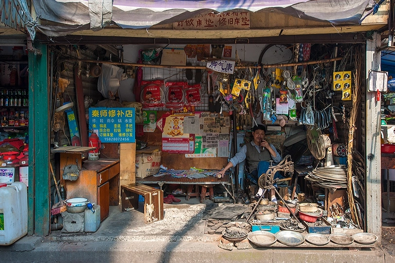 一个坐在街边小商店外面的男人