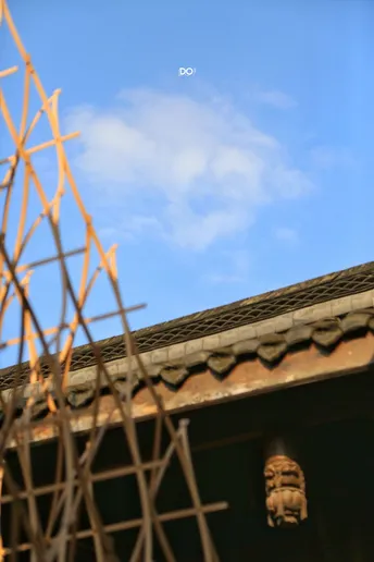 房子的屋顶上有一个脸 后面有围墙和窗户