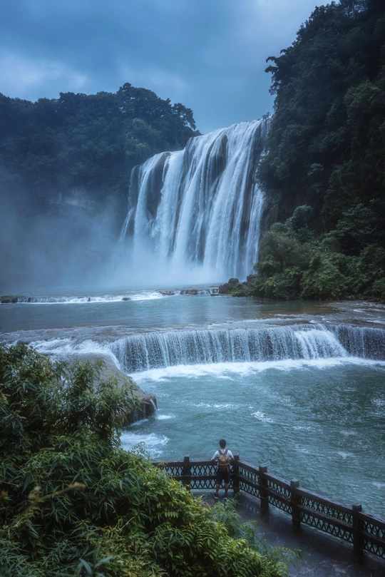 一个坐在瀑布边上看水的人
