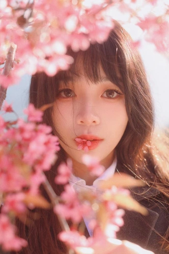 一位年轻女子拥有鲜嫩的粉红色嘴唇 紧紧抓住一棵树。