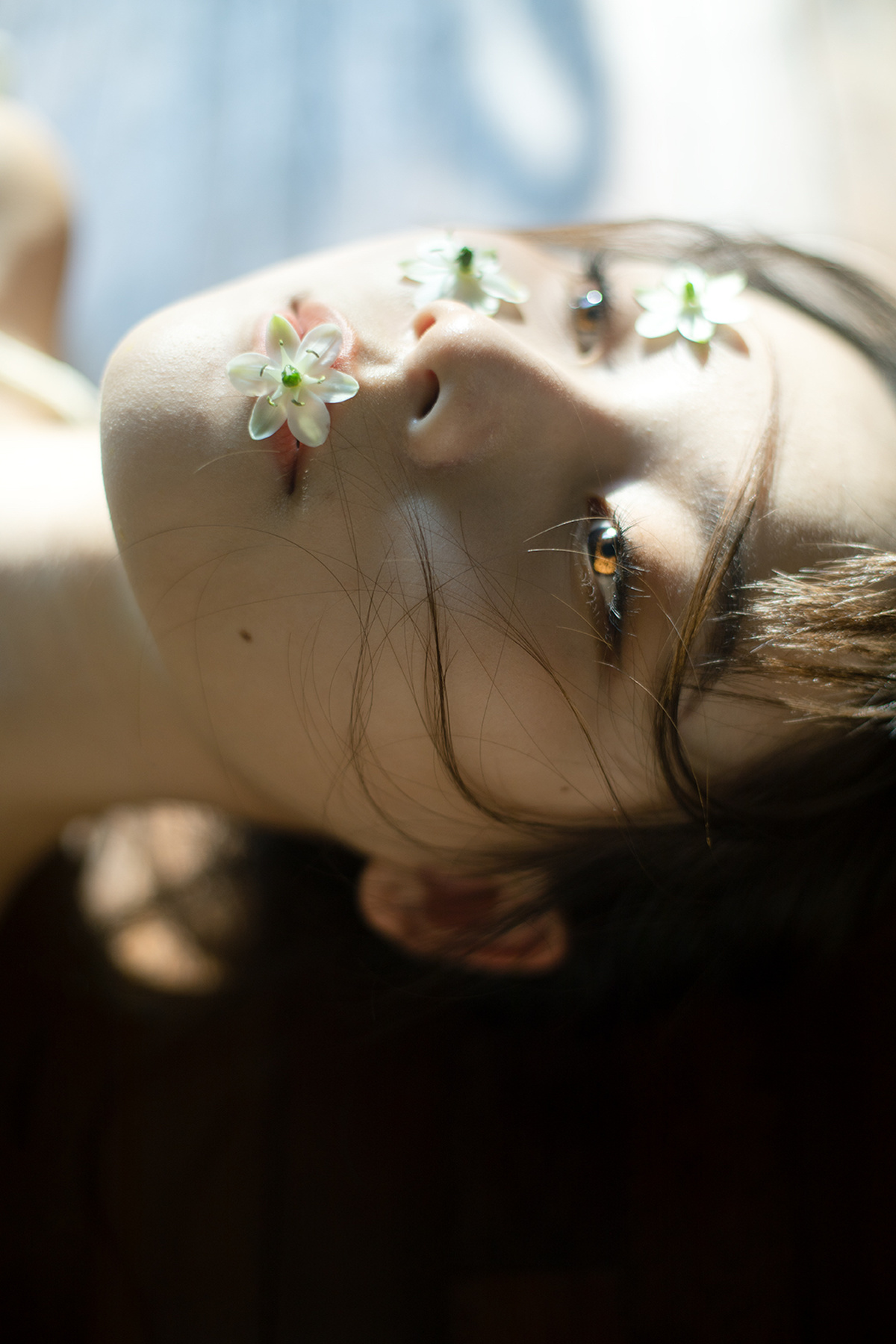 一个小女孩头上有白色的花 正在抬头看。