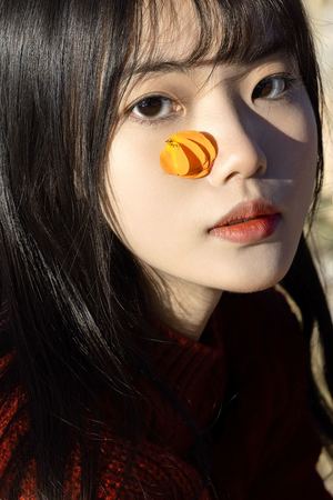 一个鼻子上涂着橙色 眼睛、嘴唇和脸上都有妆容的女人
