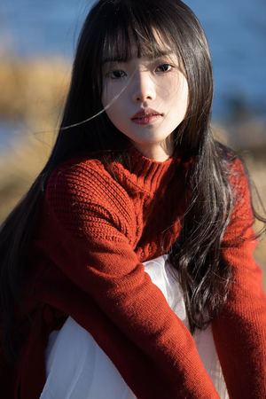 一位年轻女子穿着一件红色毛衣和围巾的肖像