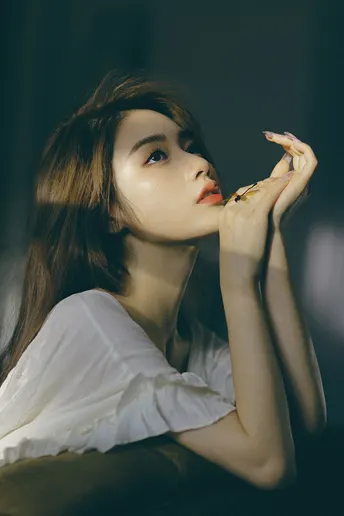 一位穿着白色衬衫的年轻女子正在吃披萨。