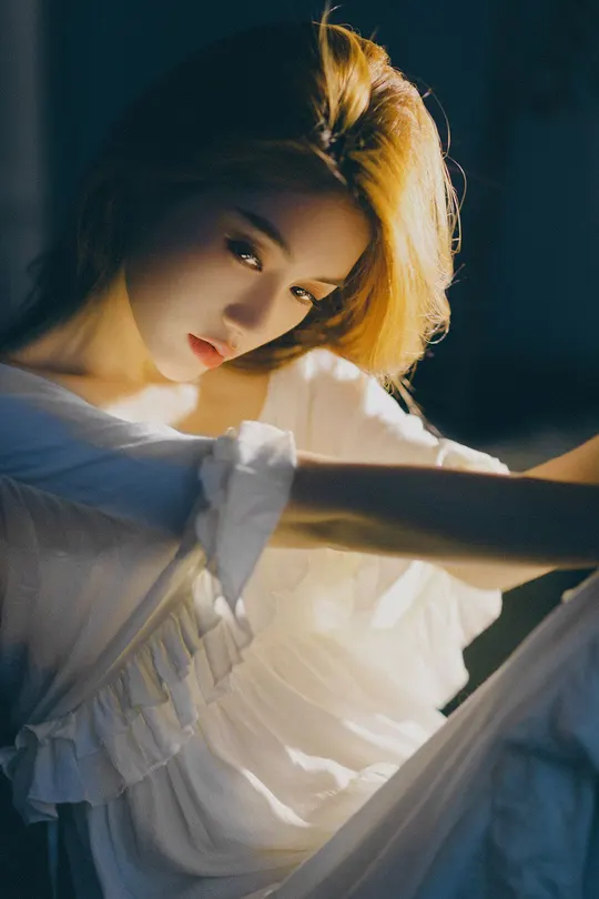 一位穿着白色连衣裙在昏暗光线下的女孩肖像