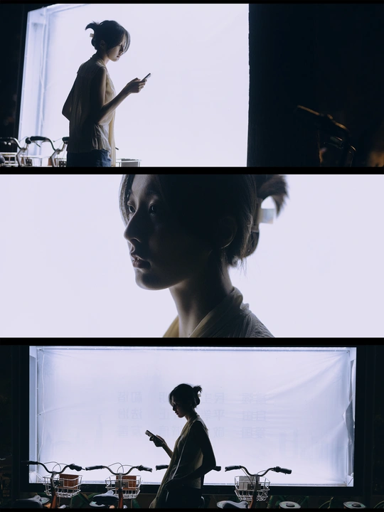 一位女性站在一个房间 正在看手机。