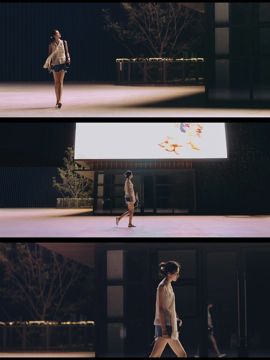 一位穿着连衣裙的女人走过一条靠近建筑物的街道