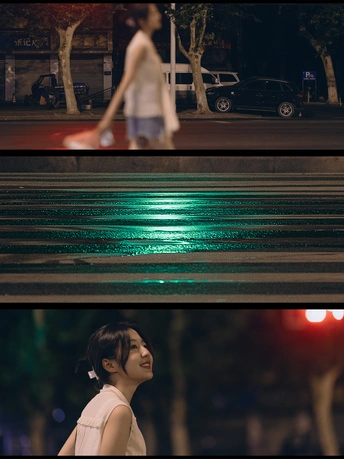 一条分割图像显示了一个穿着绿色连衣裙的年轻女子在夜晚穿越城市街道 街道尽头有一个夜晚的绿色交通信号灯