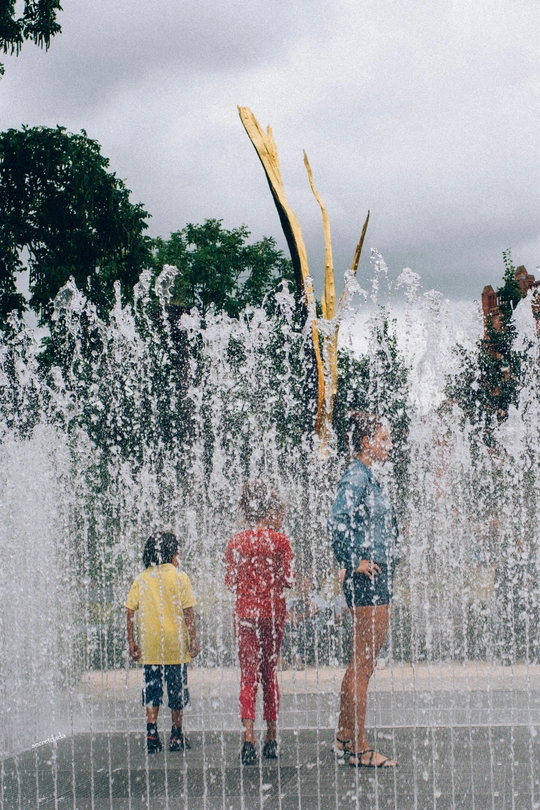 喷泉里的小男孩们和在水里站着的人们