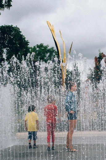 喷泉里的小男孩们和在水里站着的人们