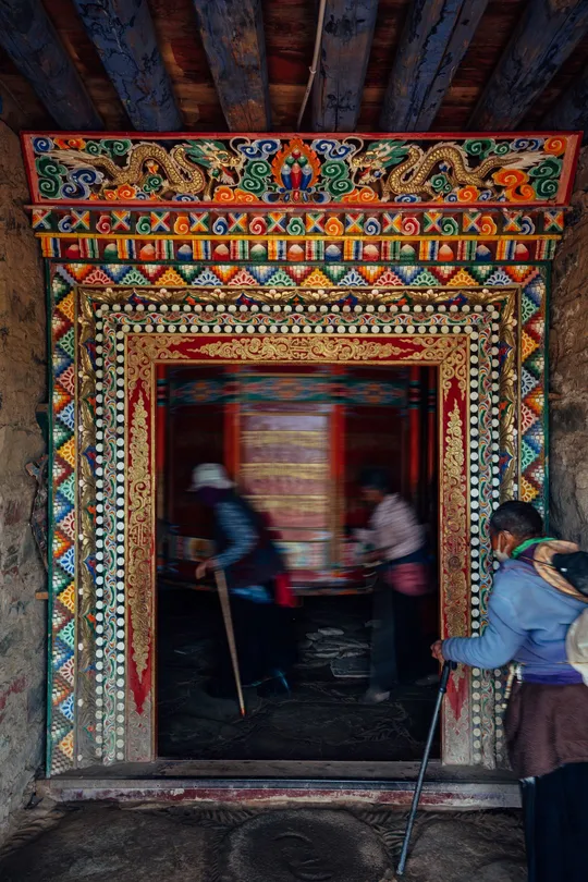 一位妇女站在一座古老寺庙内的彩色房间入口处