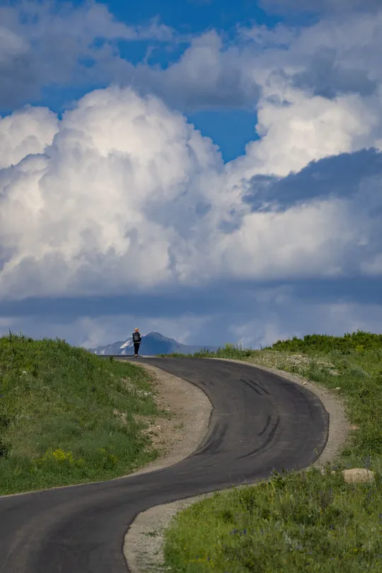 一个人在山顶上 天空中飘着云。