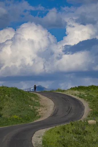 一个人在山顶上 天空中飘着云。