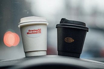 汽车仪表板上放着几杯咖啡