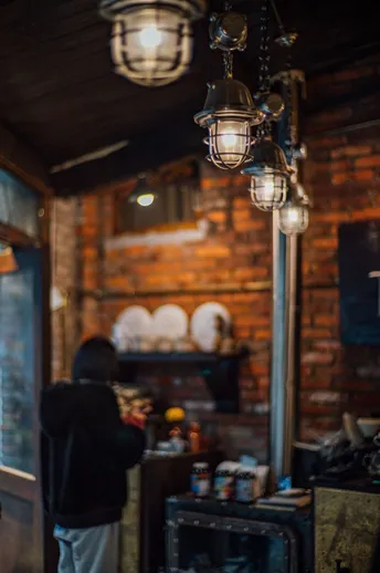 站在餐厅柜台旁 注视着昏暗的厨房的一名男子