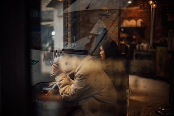 一位女性正在看手机 而一位男性坐在外面