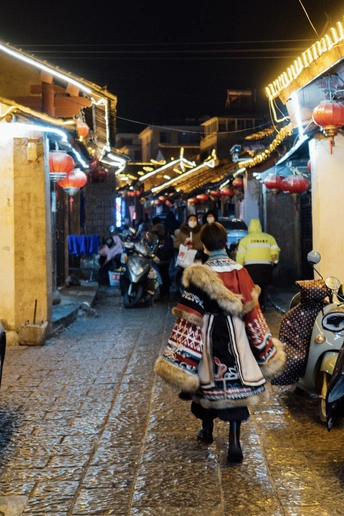 夜晚的巷子里 有人行走 摩托车和滑板车。