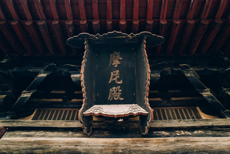 一把旧椅子坐在木屋顶下