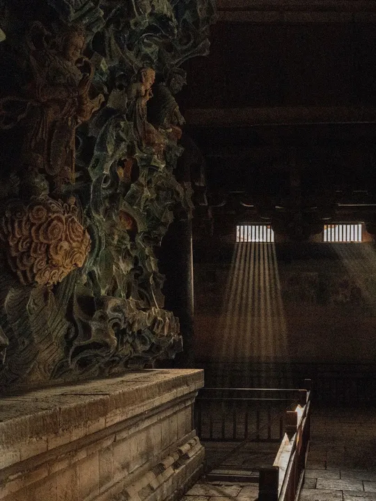 一个黑暗的房间 有长凳 光线透过窗户进来。