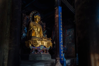 一座黑暗寺庙中的大型金色佛 buddha  statue