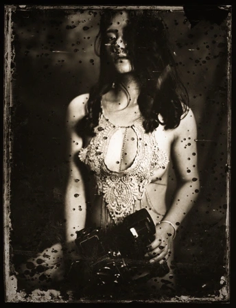 一张黑白照片 一位年轻女子手持相机