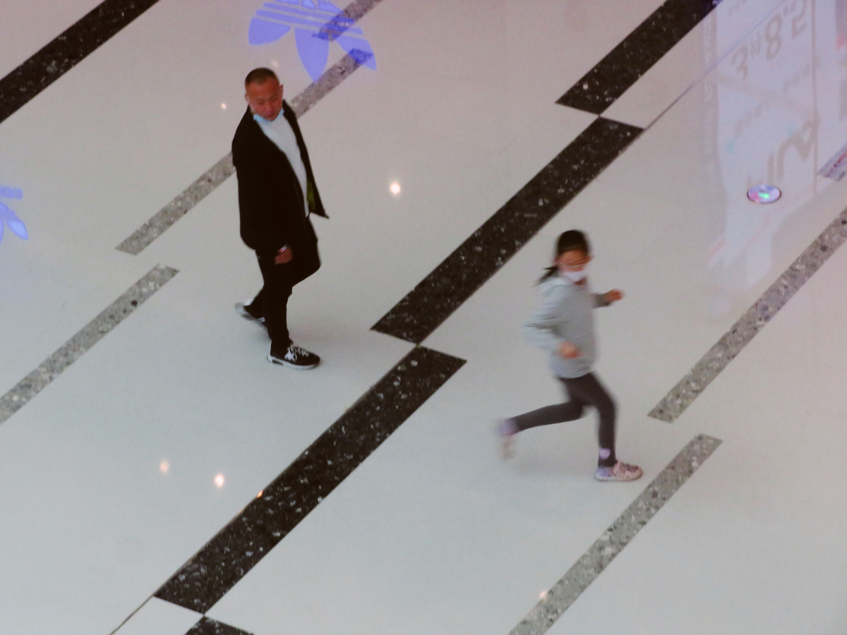 一个人和一个女人正在走过一个铺有瓷砖的地板。