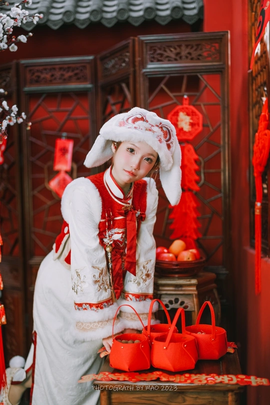 一位穿着白色连衣裙和帽子 身着红色服装的年轻女子