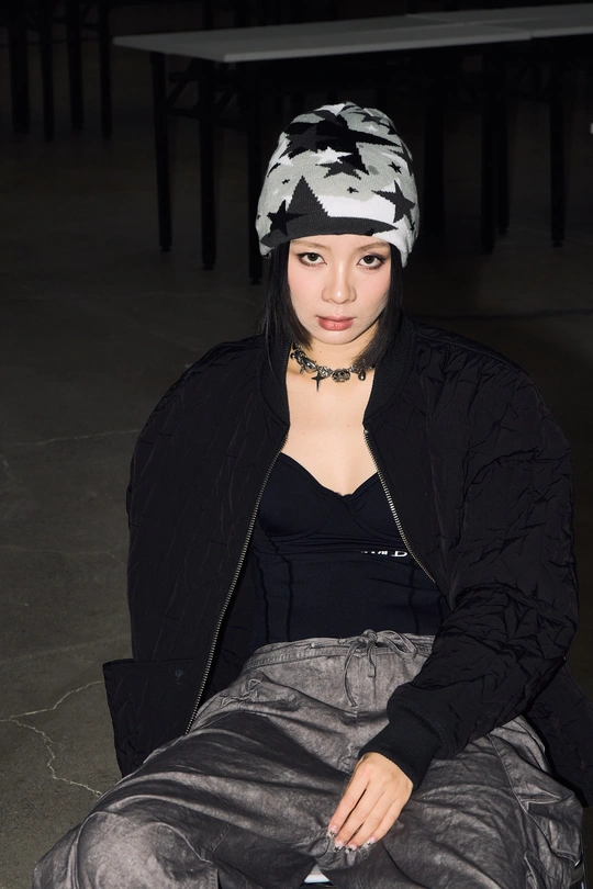 一个穿着黑白相间毛线帽的年轻女子坐在地板上