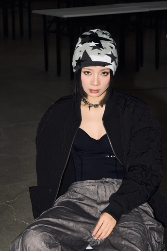 一个穿着黑白相间毛线帽的年轻女子坐在地板上