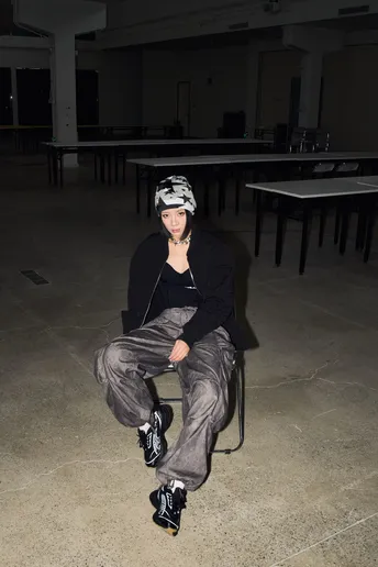 一个年轻男子坐在一个空荡荡的房间里的一把椅子上。