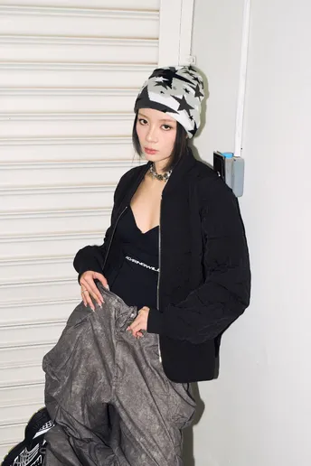 一位穿着黑色帽子和灰色裤子的年轻女子