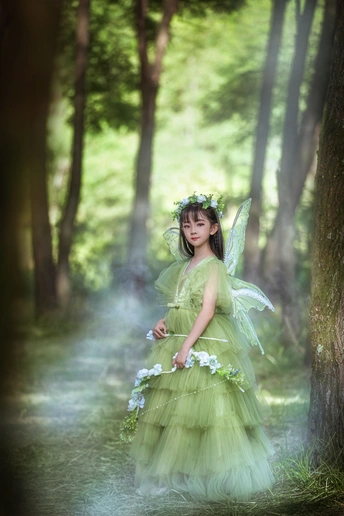 一个穿着绿色衣服的年轻女人在树林里 带着花和绿色连衣裙