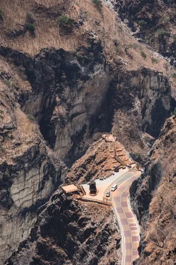 一辆在山间峡谷中行驶的盘山公路上的汽车
