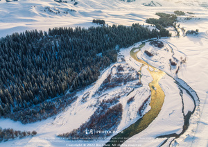 山谷上的 aerial landscape 带有河流和一棵棵被雪覆盖的大树。