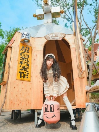 一位年轻女子在像树屋一样的小木屋前摆姿势
