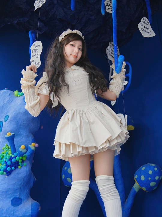 一个穿着白色连衣裙、蓝色袜子和靴子的年轻女孩