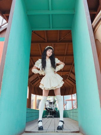 一位穿着白色连衣裙和高筒靴子的女士