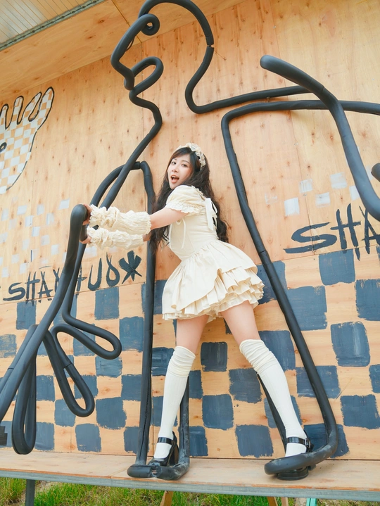 一个穿白裙子的年轻女子正在爬一面高墙