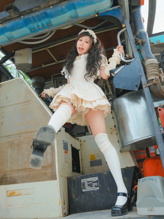 一个小女孩穿着一件白色连衣裙站在一辆卡车上