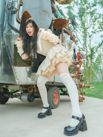 一位穿着白裙子和袜子的年轻女子在金属物体前摆姿势