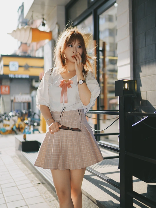 一位穿着短裙和衬衫的年轻女子