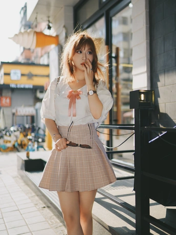 一位穿着短裙和衬衫的年轻女子