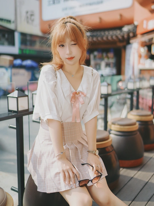 一位年轻女子穿着打扮并摆姿势