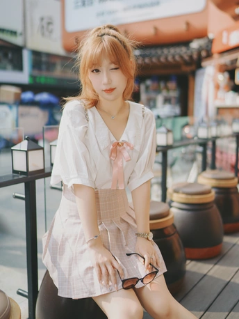 一位年轻女子穿着打扮并摆姿势